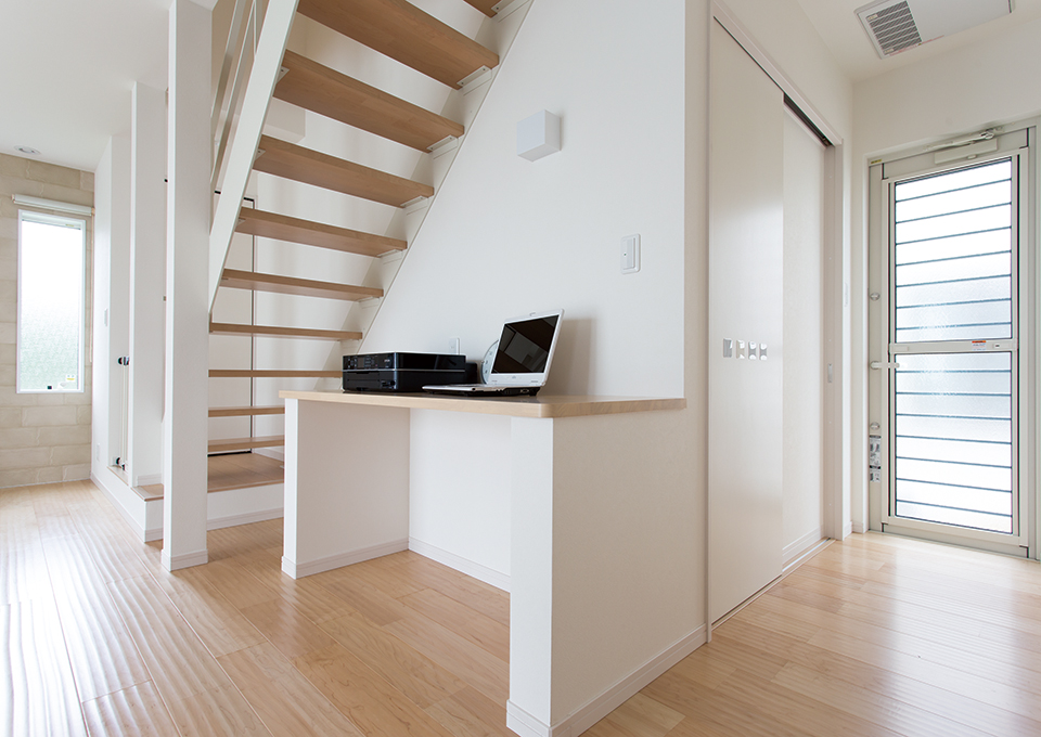 リビング階段は、圧迫感のないデザインに。階段の下に造作カウンターを設けて、空間を有効に活用しています。