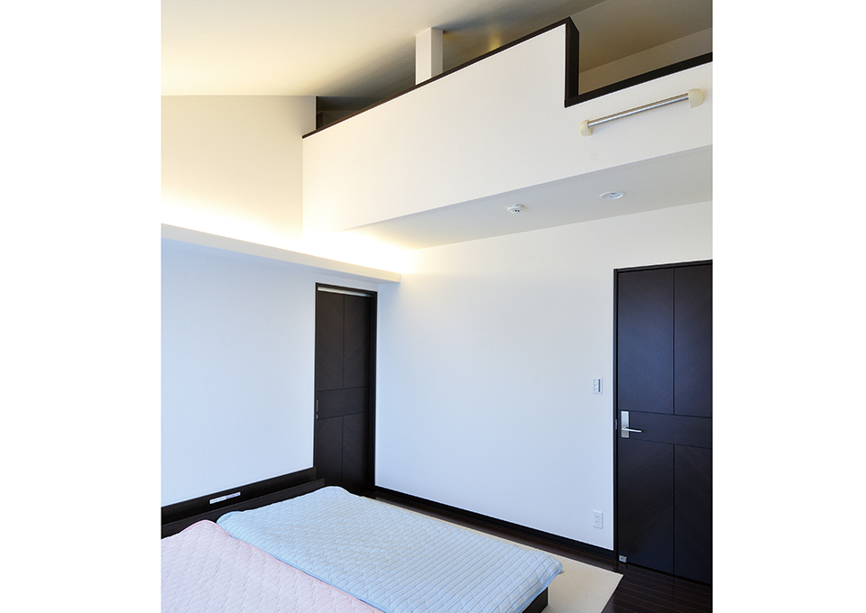 勾配天井の寝室は、高い位置にロフトを設けて収納スペースを確保しています。