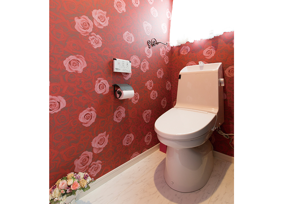 トイレにはバラ模様のクロスを採用。白い床に合わせて幅木も白くしているところがポイントです。
