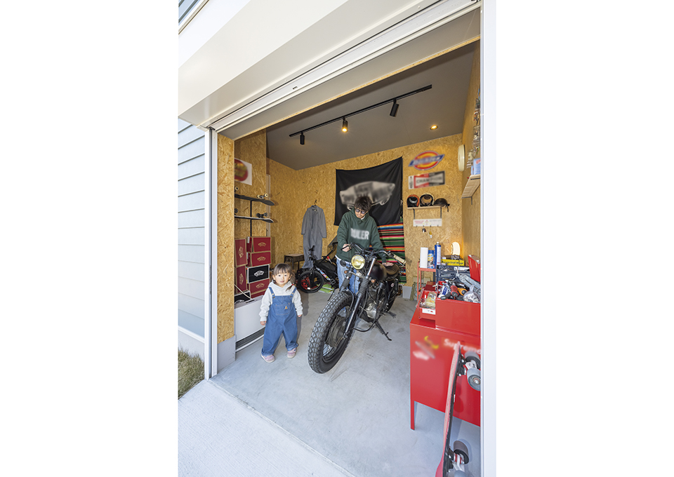 工具やお気に入りの品を並べたバイクガレージは、玄関ホールともつながっています。