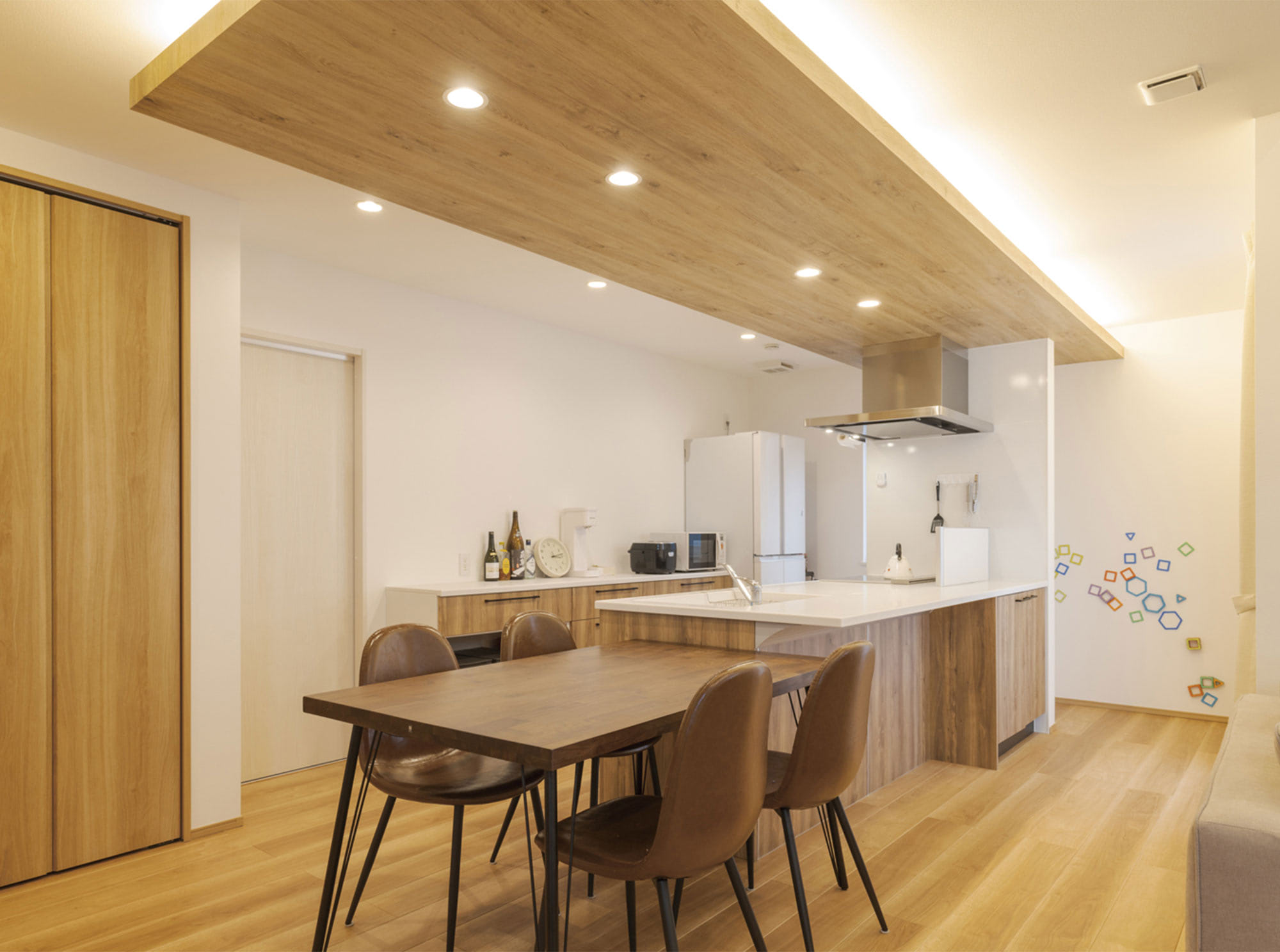 ダイニング＆キッチンは、間接照明を施した木目の下がり天井がやわらかい雰囲気を創り出しています。